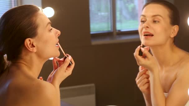 Jung Brünette Apllying Lippenstift Looking Auf Die Spiegel — Stockvideo