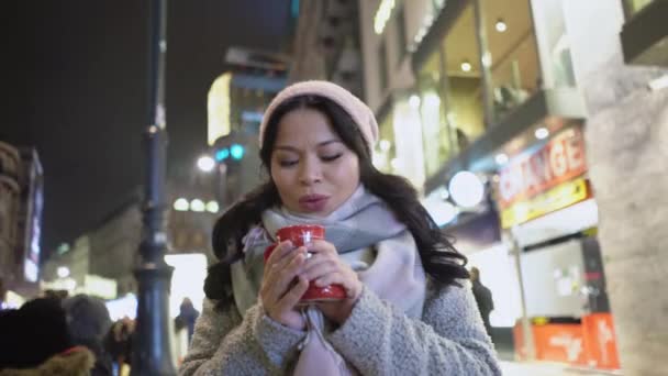 Ásia morena mulher beber Quente café no um noite cidade vida fundo — Vídeo de Stock