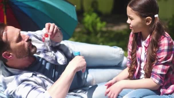 Otec učí dceru mýdlové bubliny — Stock video