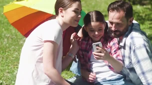 Alegre familia disfrutando de tiempo juntos en el parque de verano en fin de semana — Vídeo de stock