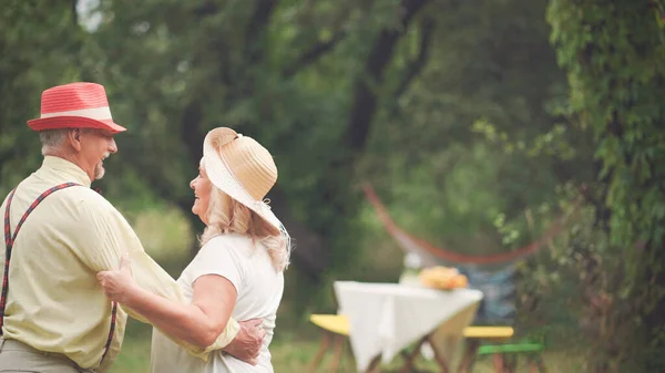 Dansen van ouderen paar in de zomertuin — Stockfoto
