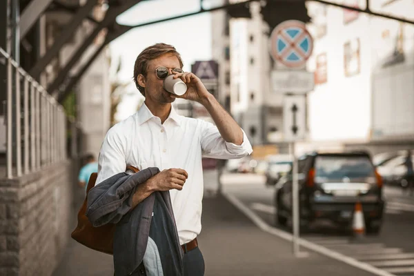 Well-dressedyoung man drinking coffee outdoors. — Stock Photo, Image