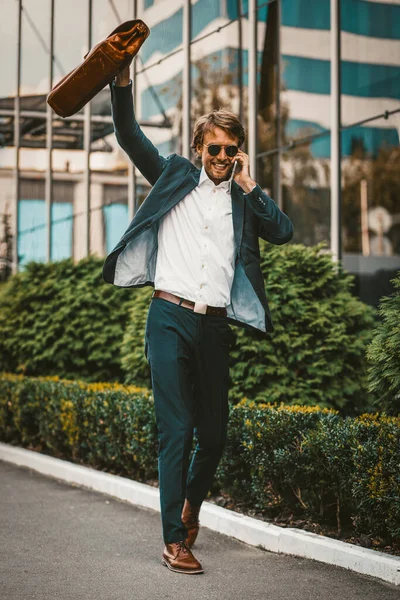 Businessman celebrating success walking by the office building — Stock Photo, Image