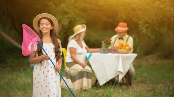 Charmantes junges Mädchen mit rosa Schmetterlingsnetz — Stockfoto