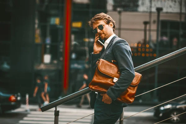 Empresário de aparência inteligente tendo conversa no telefone fora do centro de negócios — Fotografia de Stock