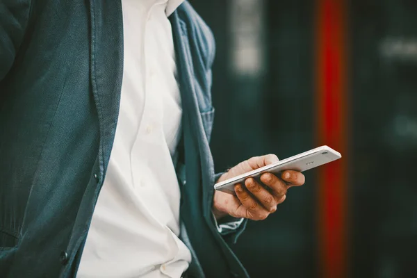 Επιχειρηματίας στέκεται με smartphone και γραπτών μηνυμάτων — Φωτογραφία Αρχείου