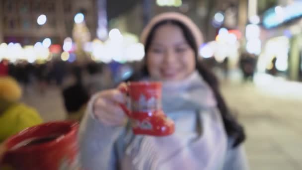 Žena pije horký nápoj ve vánočním městě — Stock video