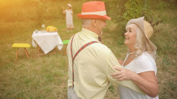 Stará dáma a gentleman tančí v zahradě — Stock fotografie