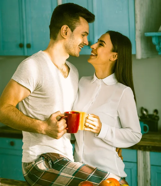 Man och kvinna ler ansikte mot ansikte i köket — Stockfoto