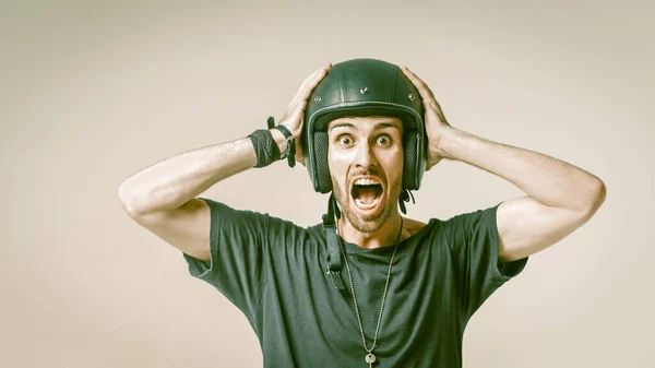 Hombre gritando en el casco agarrando la cabeza en la espalda gris —  Fotos de Stock