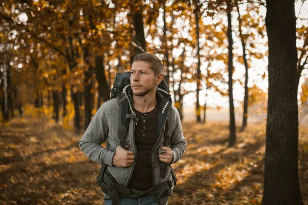 Mochileiro jovem caminhando na floresta de outono — Fotografia de Stock