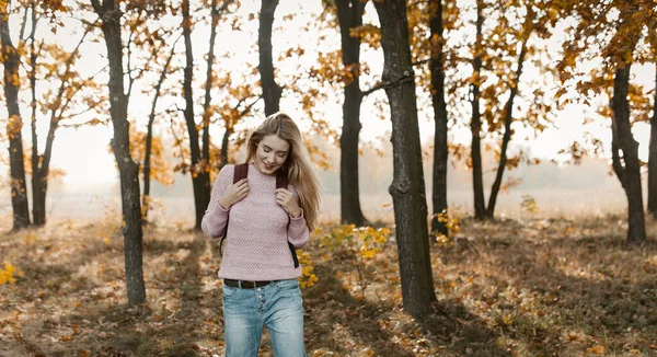 Un viaggiatore femminile sorridente cammina in una bella natura — Foto Stock