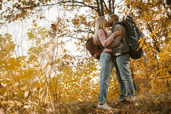 Casal jovem de turistas beijando na floresta ao ar livre — Fotografia de Stock