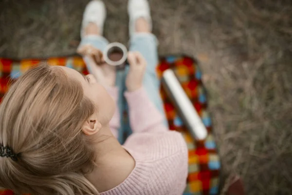 Blond vrouw met warme drank op de picknick in de natuur — Stockfoto
