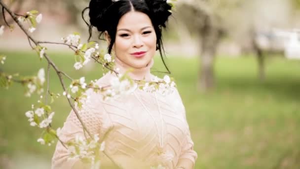 Hübsch asiatisch erwachsene frau im blühen garten — Stockvideo