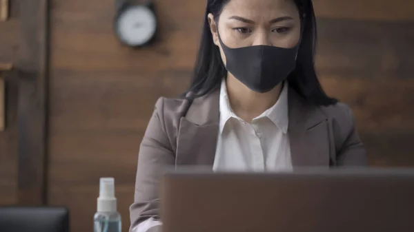 Trabalhador de escritório na máscara médica que trabalha no portátil — Fotografia de Stock
