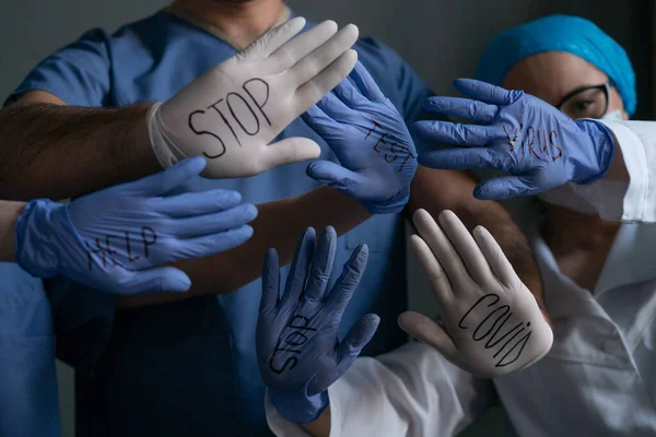 Gruppe von Sanitätern zeigt auf Handschuhen geschriebene Titel — Stockfoto