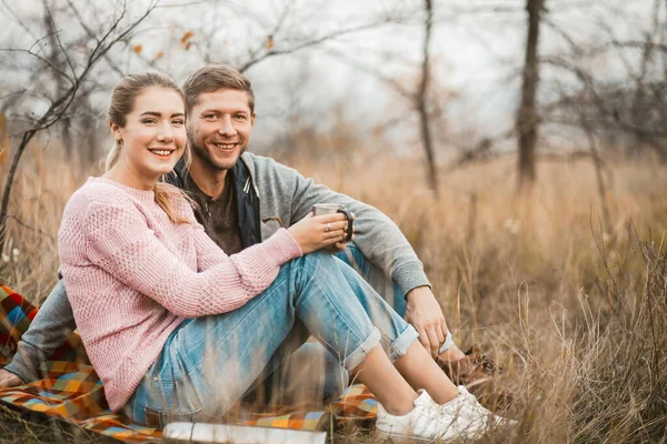 Pareja feliz sentada en la manta de picnic al aire libre — Foto de Stock