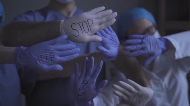 Médicos vistiendo uniforme médico con signos en allí guantes desechables . — Vídeo de stock