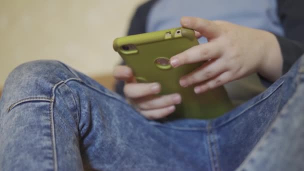 Close up on boy playing games sitting nudred at home. — Stock video