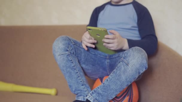 Menino sentado em uma bola de futebol e jogando jogos de aducational no programa de educação em casa . — Vídeo de Stock