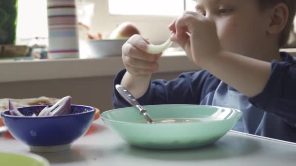 Jeune garçon assis à la table de salle à manger manger — Video