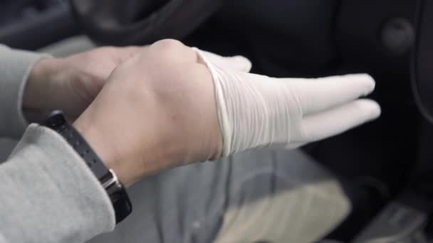 A sofőr férfi egyszer használatos kesztyűt vesz fel, és vásárolni megy.. — Stock videók