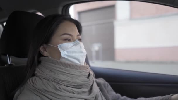 Mujer asiática conductora con máscara de contaminación paseos en la ciudad vacía — Vídeo de stock