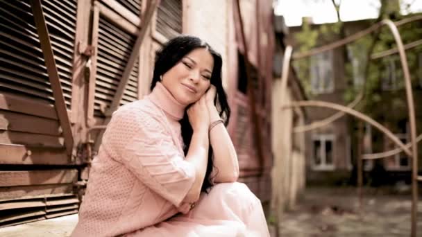 Азиатская модель сидит на лестнице, позируя на фотосессии — стоковое видео