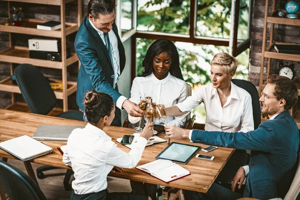 Une équipe d'affaires diversifiée boit du champagne au bureau — Photo