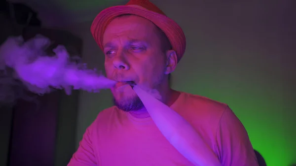 Palacz z Hookah wydycha dym w neon podświetlone — Zdjęcie stockowe