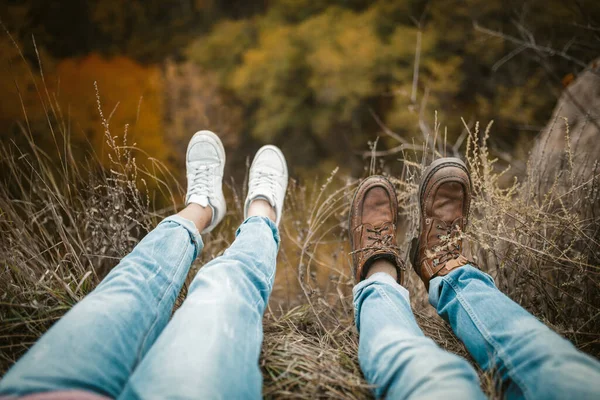 Man en vrouw rust op klif rand met benen naar beneden hangen — Stockfoto