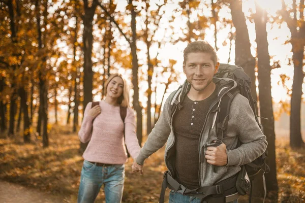 Hermosa pareja de viajeros caminan a lo largo de un sendero forestal —  Fotos de Stock