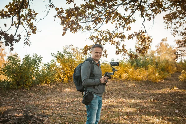 Lächelnder Filmemacher bereitet Kamera für Videoaufnahmen vor — Stockfoto