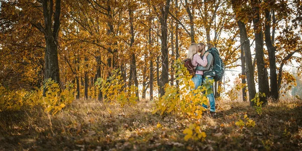 Een paar toeristen zoenen in het zonnige herfstbos — Stockfoto