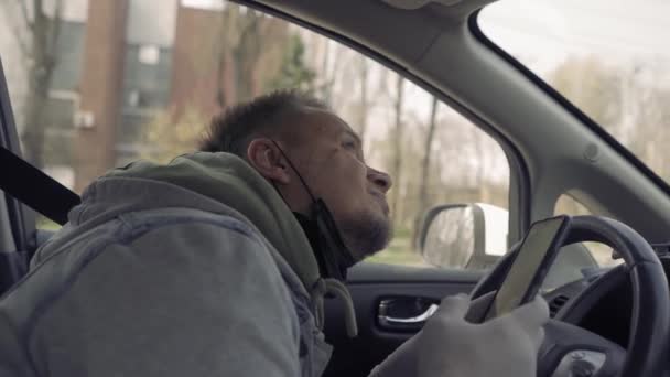 Warten an einer Kreuzung bei grüner Ampel Fahrer schaut auf das Telefon. — Stockvideo