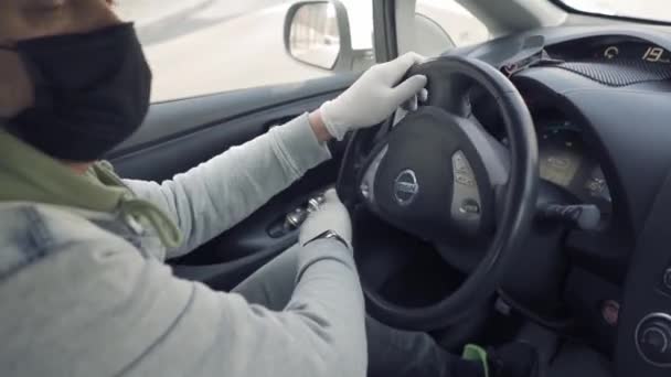 Freelancer on the way to work driving car in protective mask and gloves. — Stock Video