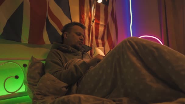 Man met griep aan de telefoon die alleen in bed zit. — Stockvideo