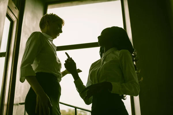 Duas silhuetas de mulheres de negócios na luz do sol — Fotografia de Stock