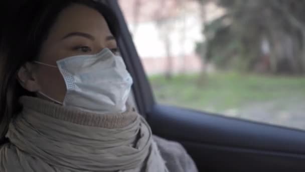 Une femme asiatique conduisant une voiture portant un masque anti-pollution dans la ville vide et en quarantaine de la pandémie 19. Femme asiatique chevauchant pour travailler dans la voiture. Prores 422 . — Video