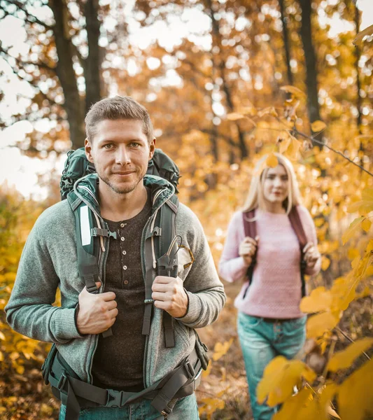 Een paar Backpackers wandelen door het Herfst Bos — Stockfoto