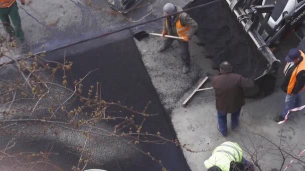 Άσφαλτος pavers εργασία για το δρόμο κλείδωμα ή τη δημιουργία ενός νέου στρώματος ασφάλτου, αντί ρωγμές και τρύπες. Αντιπροσωπείες 422. Κίεβο, Ουκρανία. Απρίλιος 2020 — Αρχείο Βίντεο
