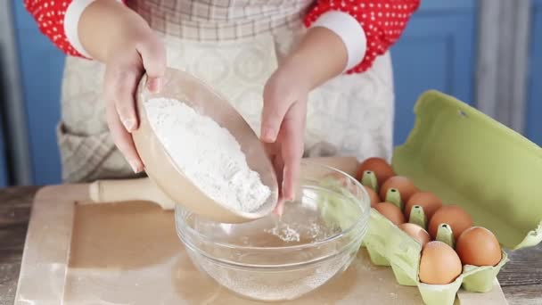 Mamãe prepara panquecas ou muffins para crianças, derramando farinha em uma tigela de mistura e freios de um ovo em uma cozinha azul vintage em uma casa de campo. Fecha. Prores 422 — Vídeo de Stock
