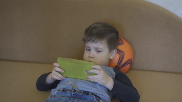 Gra poznawcza bawiąca się w małego chłopca spędza czas w kwarantannie koronawirusu, podczas gdy jego rodzice pracują przy komputerze. Rodzina zostaje w domu. Prores 422 — Wideo stockowe