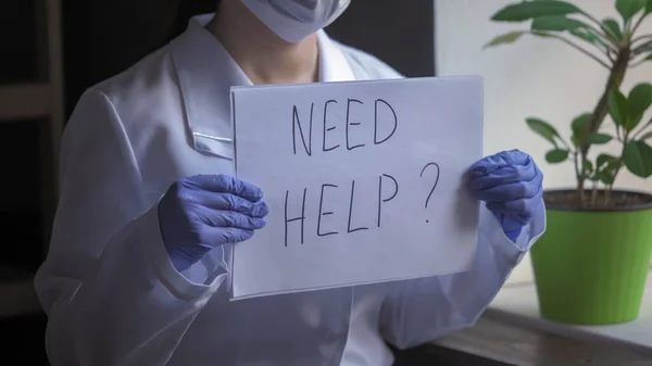 Close up de médicos mãos segurando uma folha de papel com a oferta de ajuda. Feminino Medic em uniforme branco em luvas descartáveis Oferece Ajuda — Fotografia de Stock