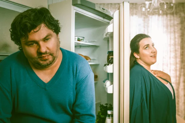 Cuplu grijuliu corp-pozitiv stă lângă frigiderul deschis în bucătăria de acasă — Fotografie, imagine de stoc