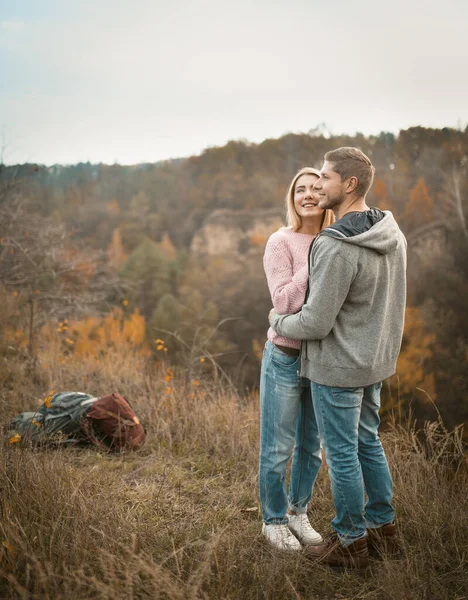 Jovens turistas estão abraçando na beira de um penhasco inalando os aromas da natureza outono — Fotografia de Stock