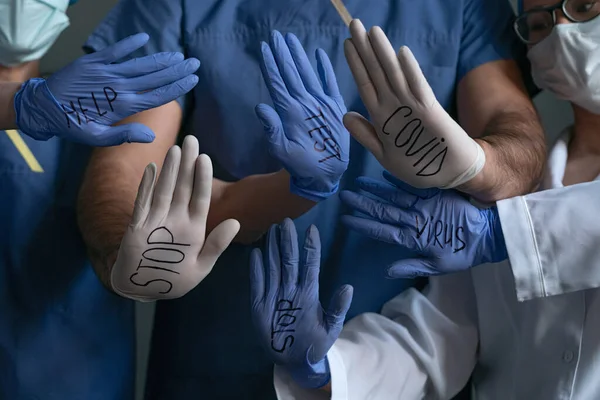 Medicii care prezintă semne pe palme se opresc, ajută, VIRUS, COVID. Modelul abstract din mâinile lucrătorilor medicali care poartă mănuși de unică folosință cu inscripții privind pandemia de coronavirus — Fotografie, imagine de stoc