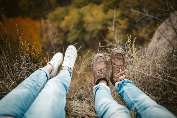 Jongeman en vrouw zitten op de rand benen naar beneden te hangen. — Stockfoto