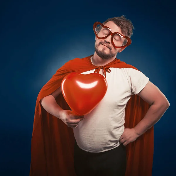 Superhéroe hombre enamorado sosteniendo gran corazón en su mano, San Valentín concepto del día — Foto de Stock